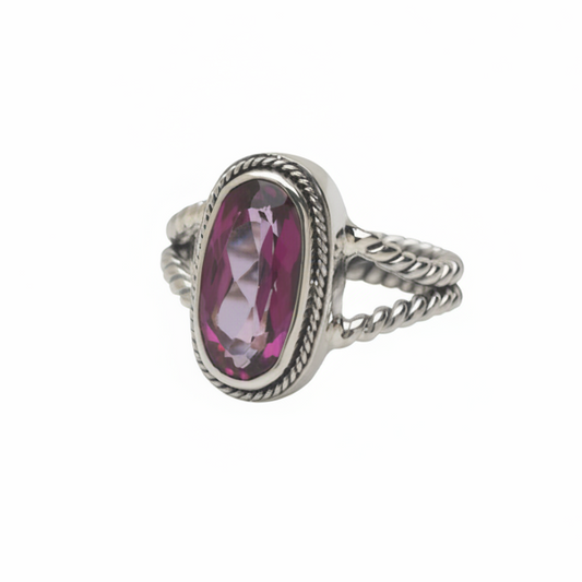 Silver ring with a pink gemstone on a white background