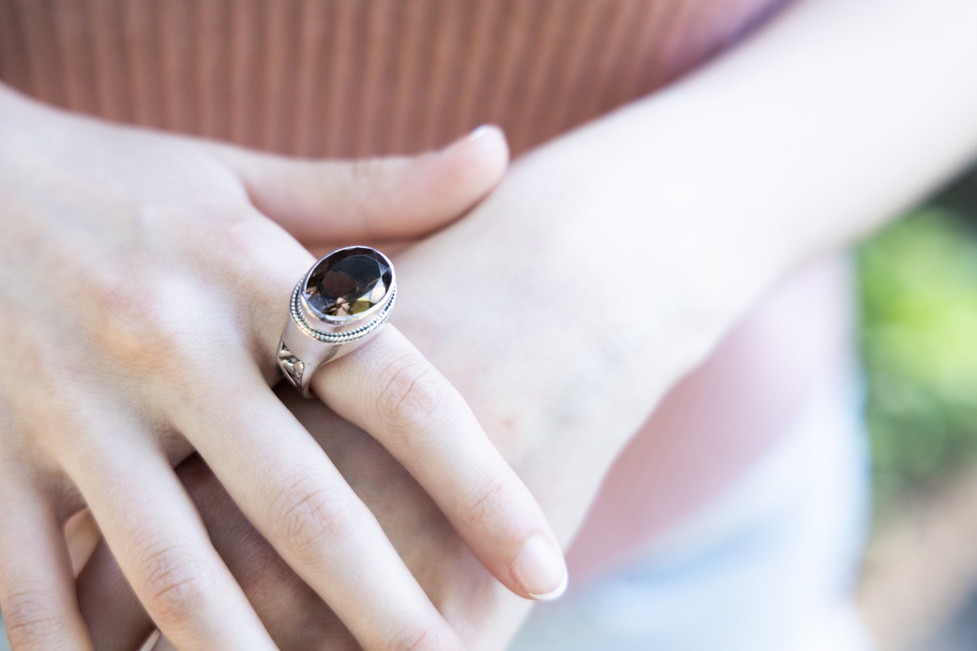 Sterling silver ring with faceted oval smoky quartz and floral repoussé shank pattern