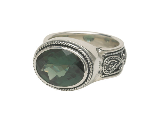 Sterling silver ring with faceted oval green spinel and paisley repoussé detailing along the shank.
