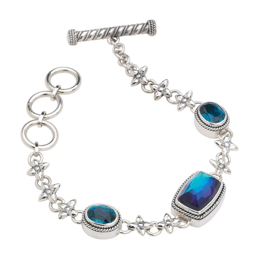 Sterling silver link bracelet with bezel-set mystic quartz and blue spinel and hand-tapped repoussé flower stations, toggle clasp, Lori Bonn Peacock Collection 2005 Archive.