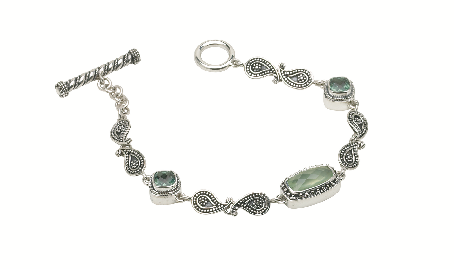 Sterling silver bracelet with prehnite and green spinel stones linked by paisley connectors.