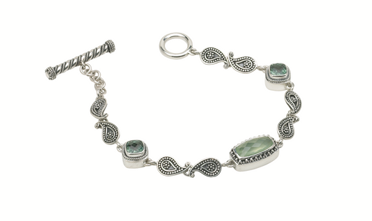 Sterling silver bracelet with prehnite and green spinel stones linked by paisley connectors.