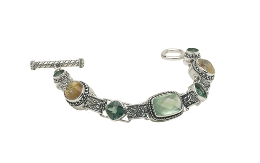 Sterling silver bracelet with prehnite, green spinel, and rutilated quartz linked by paisley repoussé connectors.