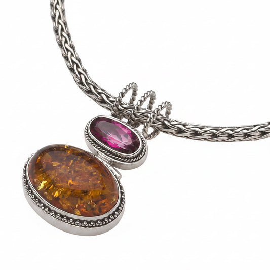 Sterling silver pendant necklace with large oval Baltic amber cabochon and faceted oval raspberry topaz in granulated bezels on handwoven snake chain, Parisian Muse Collection 2004, Lori Bonn Archive.