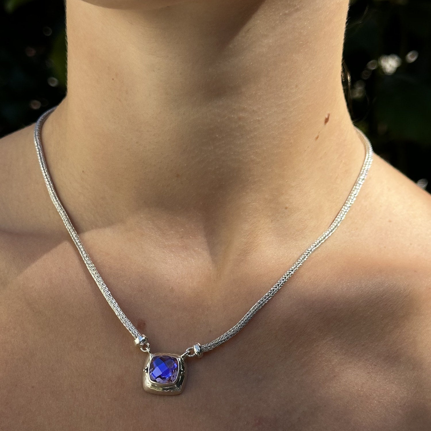 Sterling silver solitaire necklace with cushion-cut rainbow lavender quartz in a hand-hammered square setting on an adjustable handwoven snake chain, worn, Lori Bonn Splash Collection 2009 Archive sample.