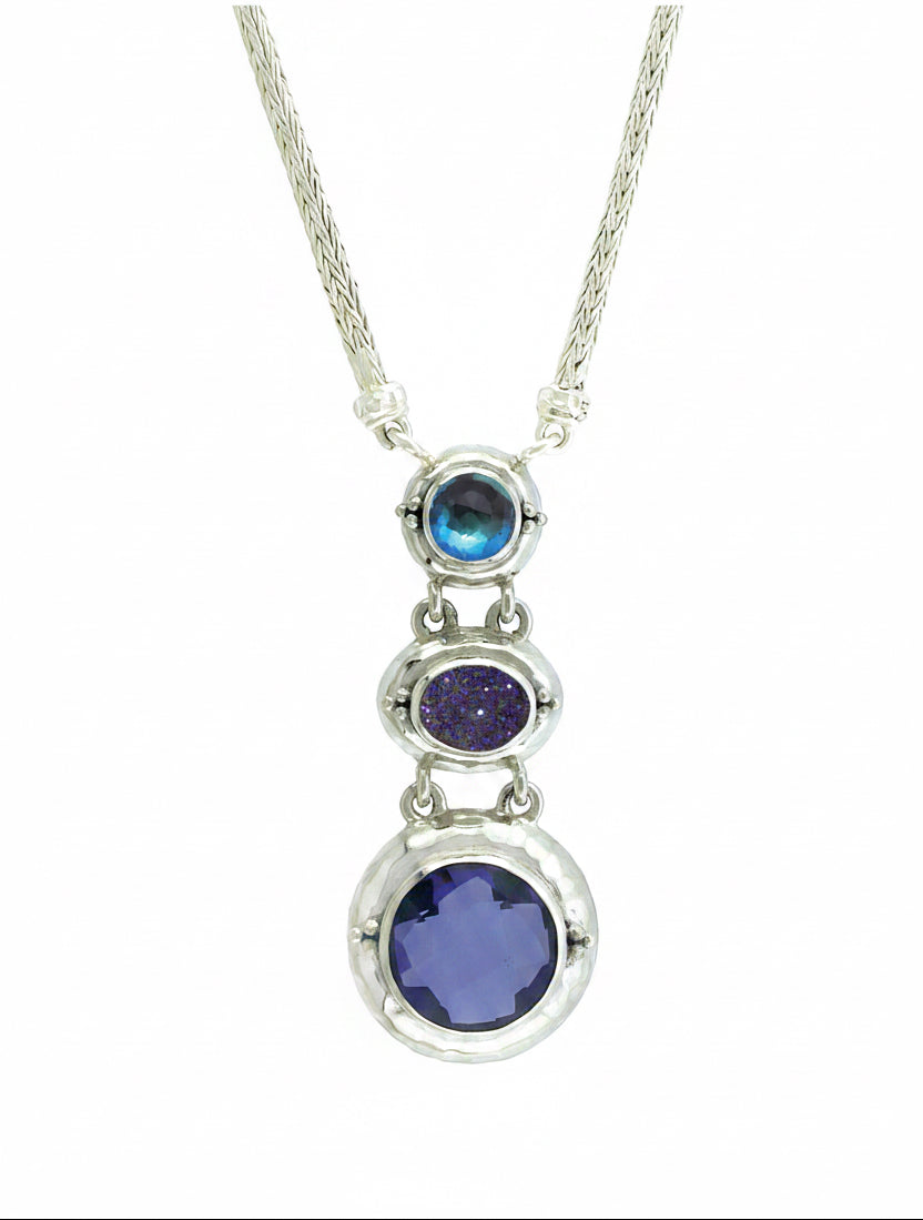 Silver necklace with three circular gemstones on a white background