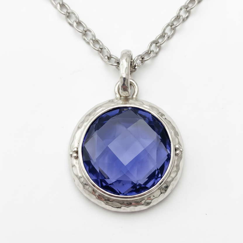 Sterling silver pendant necklace close up with large checkerboard-cut created blue sapphire in hand-hammered bezel on chain, Windsor Collection 2009, Lori Bonn Archive.