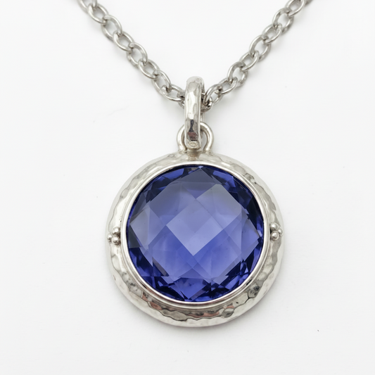 Sterling silver pendant necklace close up with large checkerboard-cut created blue sapphire in hand-hammered bezel on chain, Windsor Collection 2009, Lori Bonn Archive.