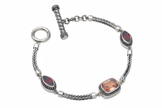 Sterling silver handwoven foxtail toggle bracelet with faceted rose gold quartz doublet cushion and marquis garnet stations in granulated bezels, Cognac Collection 2005, Lori Bonn Archive.