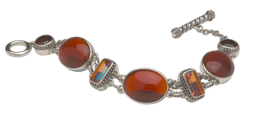 Sterling silver multi-stone link bracelet with carnelian oval cabochons, deep twilight topaz baguettes, and garnet rounds with granulated bezels and twisted rope toggle closure, Sasha Collection 2003, Lori Bonn Archive.