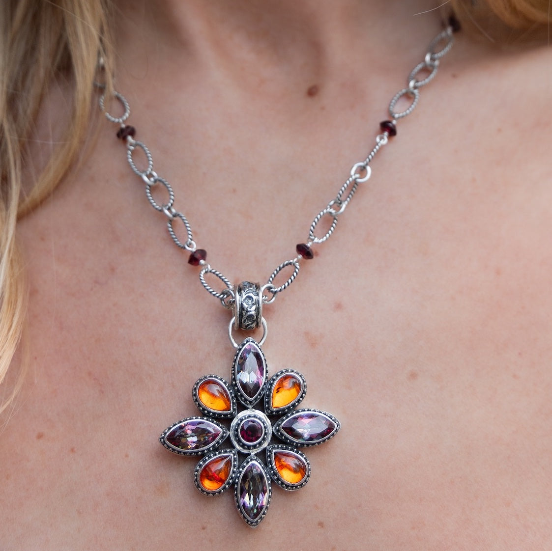 Sterling silver floral pendant featuring garnet, amber, and deep twilight topaz on an adjustable handmade chain from the Sasha 2003 Archive.
