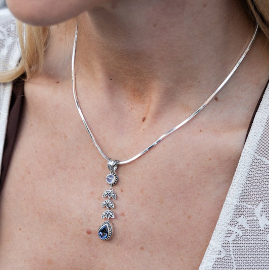 Sterling silver pendant necklace with chalcedony cabochon, granulated leaf vine link, and pear-shaped mystic fire topaz on square magic chain on model, Heirloom Collection 2002, Lori Bonn Archive.